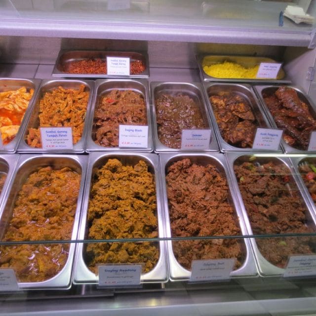 Bakken met rendang, daging blado en andere gerechten in de toonbank van de toko