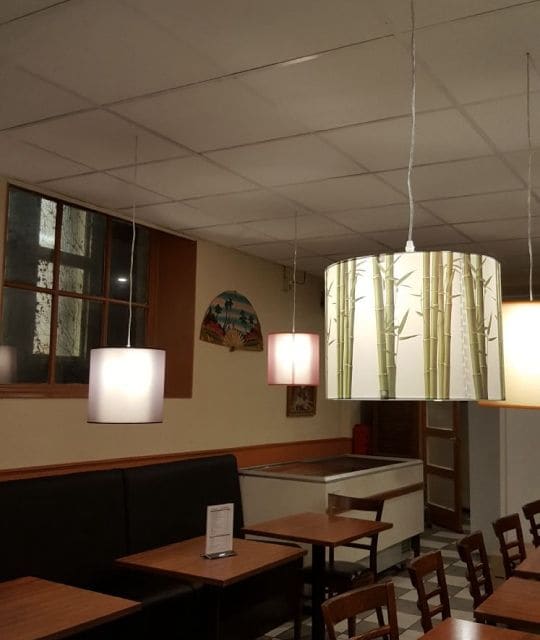 Binnen bij Java House: een lamp met bamboemotief boven de tafels