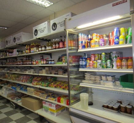 Toko-schappen met oosterse producten, specerijen en blikken